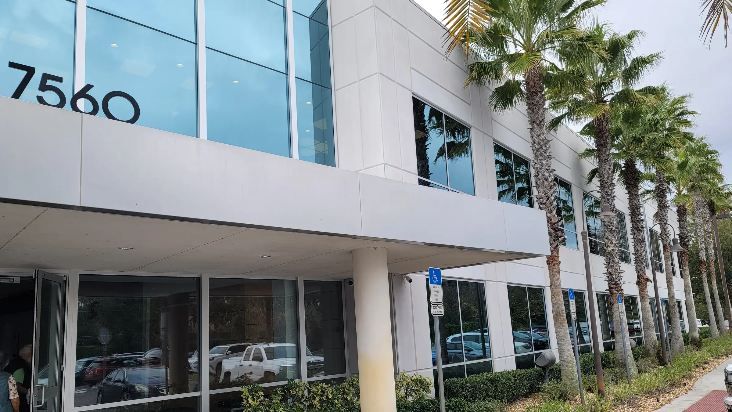 Front of the building at 7560 Red Bug Lake Rd in Oviedo, with palms and the covered entrance